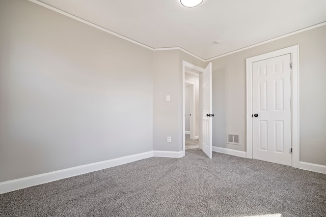 unfurnished bedroom featuring ornamental molding, carpet, visible vents, and baseboards