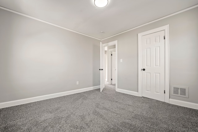 unfurnished bedroom with ornamental molding, carpet flooring, visible vents, and baseboards