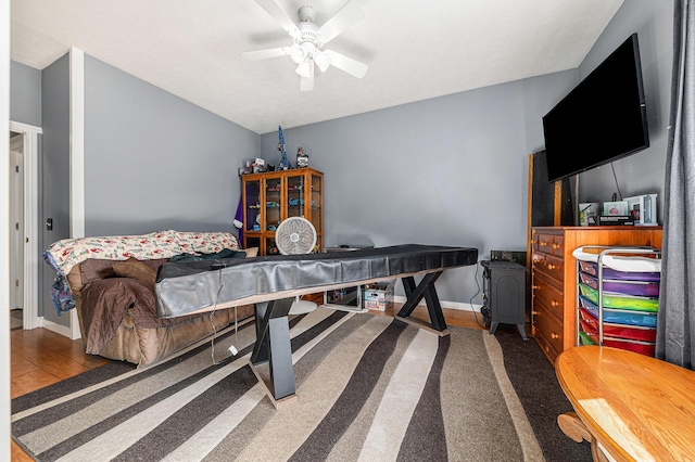 bedroom with ceiling fan, baseboards, and wood finished floors