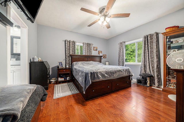 bedroom with a textured ceiling, a ceiling fan, and wood finished floors