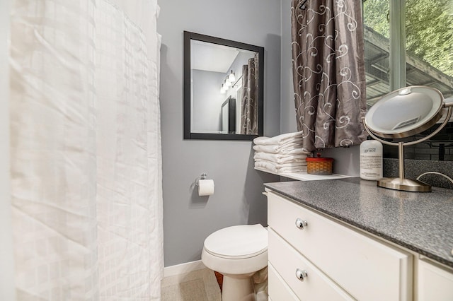 bathroom with toilet, baseboards, and vanity