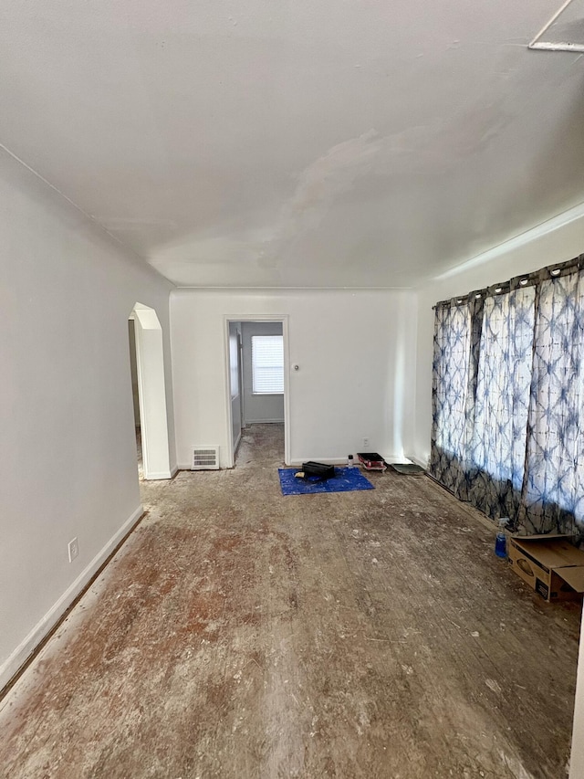 unfurnished room featuring arched walkways and visible vents