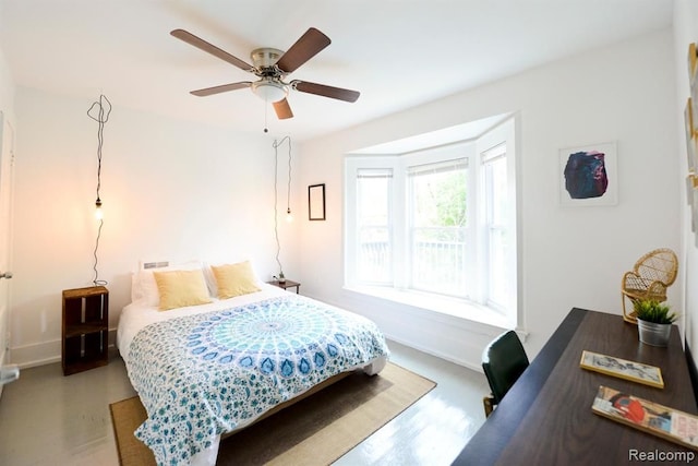 bedroom featuring ceiling fan, baseboards, and wood finished floors