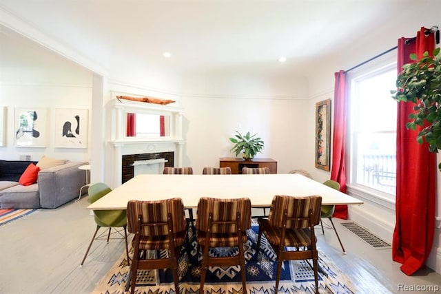 dining space featuring recessed lighting, visible vents, a fireplace, and wood finished floors