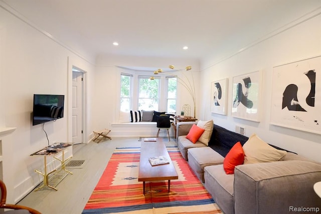 living room with baseboards, visible vents, wood finished floors, and recessed lighting