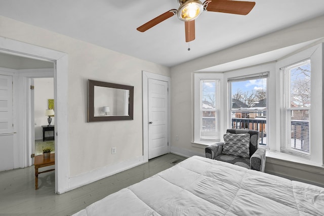 bedroom with visible vents, baseboards, ceiling fan, and wood finished floors