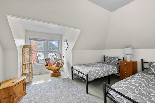 bedroom with lofted ceiling and baseboards