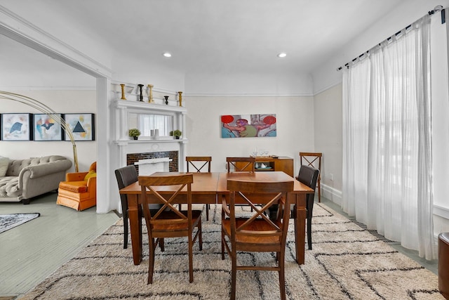 dining area with a fireplace, wood finished floors, and recessed lighting