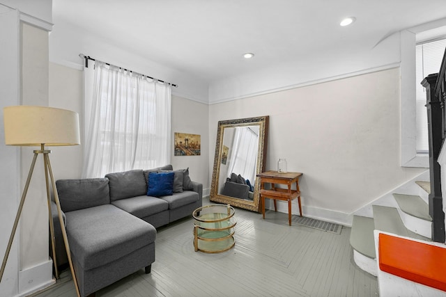 living room featuring baseboards, stairway, and recessed lighting