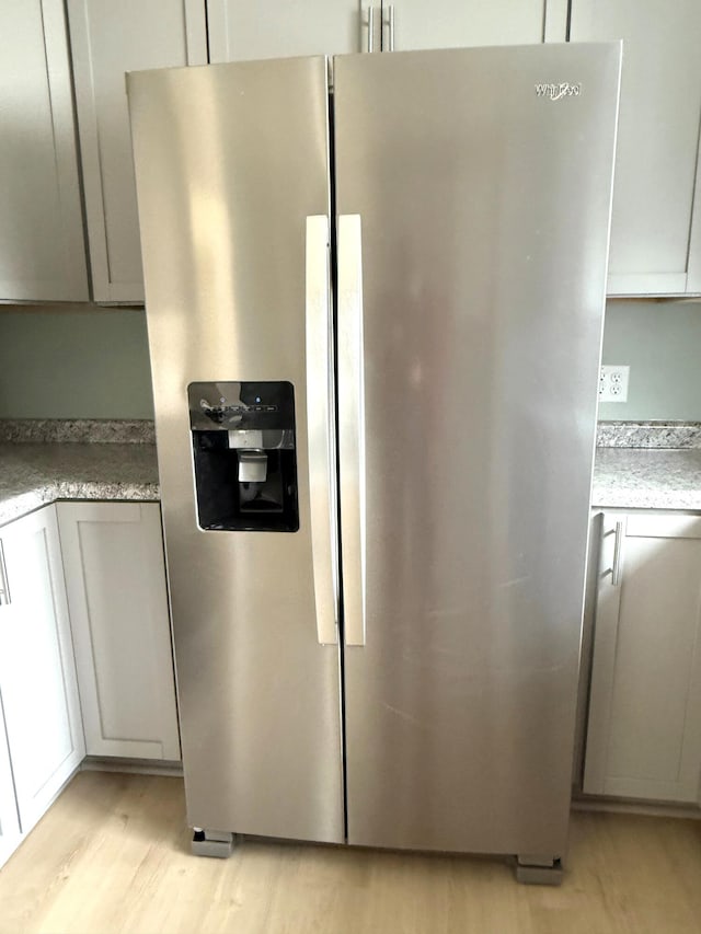 kitchen with light wood finished floors, gray cabinets, and stainless steel fridge