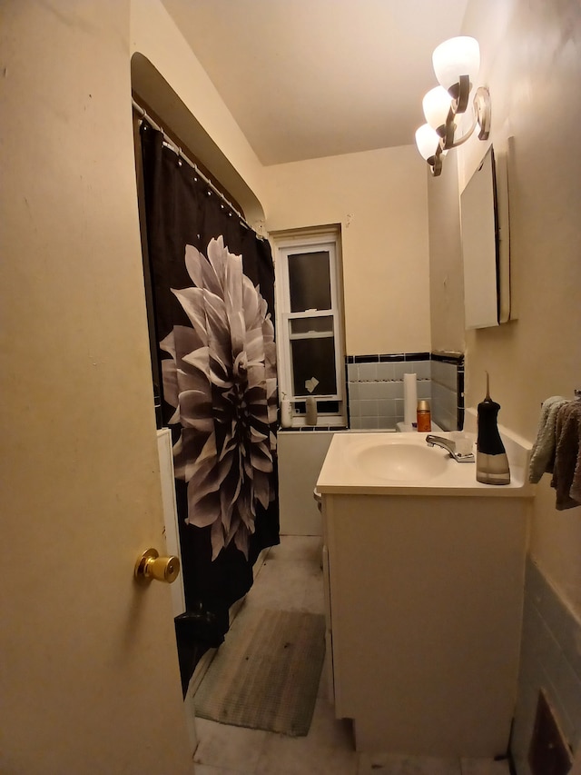 bathroom with curtained shower, vanity, and tile walls