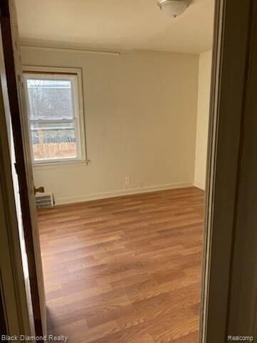 unfurnished room with light wood-style floors and baseboards