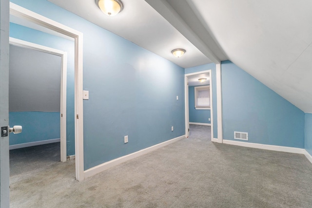 additional living space featuring lofted ceiling, carpet floors, visible vents, and baseboards