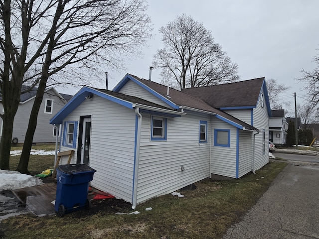 view of home's exterior with roof with shingles