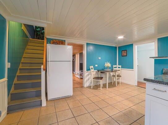 kitchen with freestanding refrigerator, wooden ceiling, and light tile patterned floors