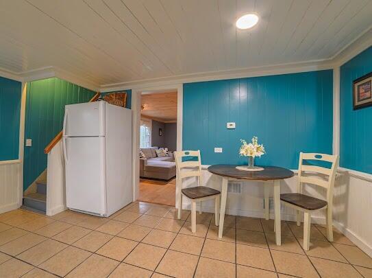 dining area featuring wood ceiling, tile patterned flooring, and ornamental molding