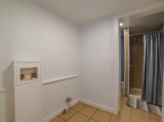 laundry room featuring laundry area, light tile patterned flooring, hookup for a washing machine, and baseboards