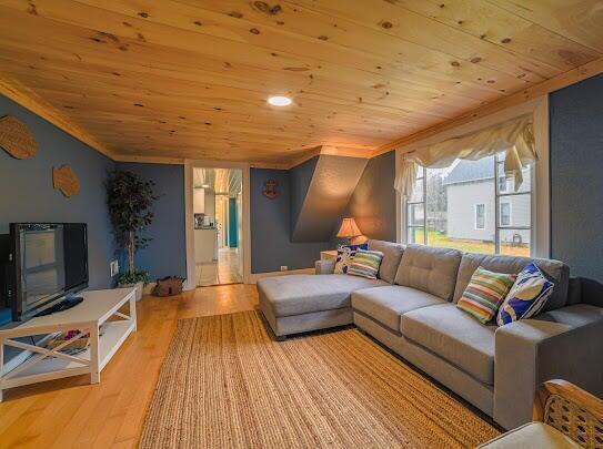 living area with wooden ceiling and wood finished floors