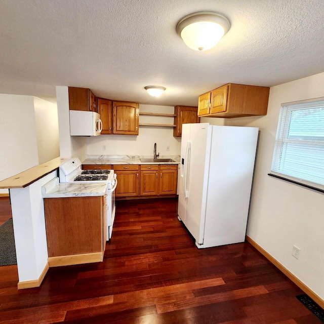 kitchen with brown cabinets, light countertops, dark wood-type flooring, a sink, and white appliances