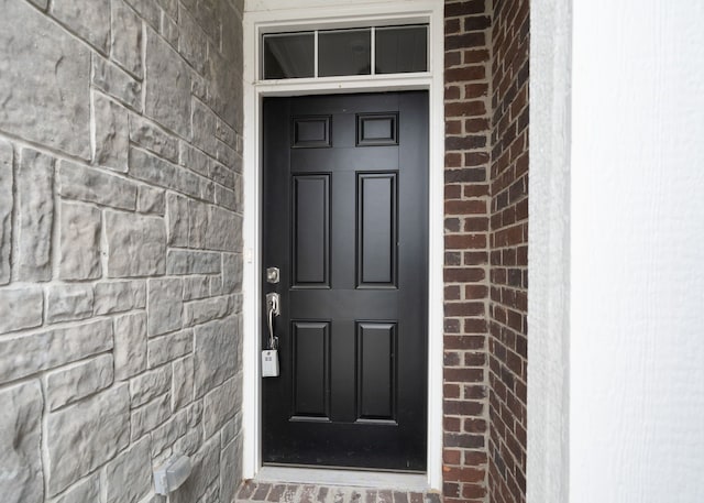 view of exterior entry with brick siding