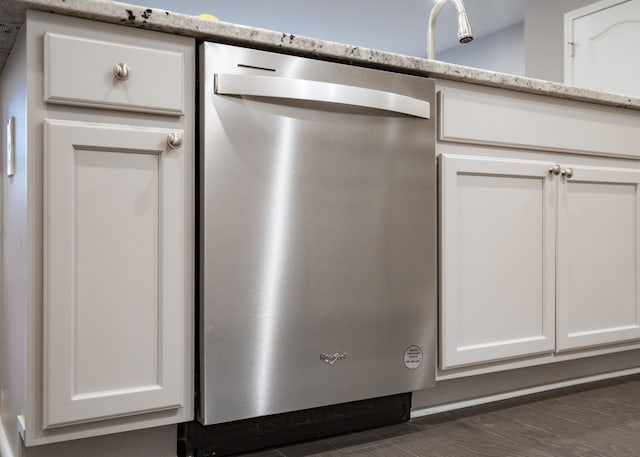 room details with white cabinetry, dishwasher, and a sink