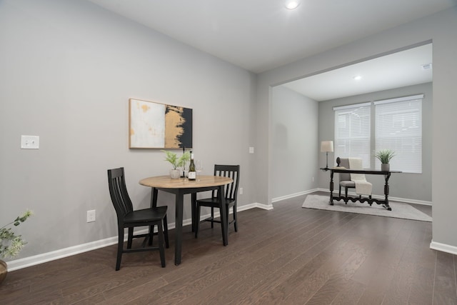 dining space featuring baseboards and wood finished floors