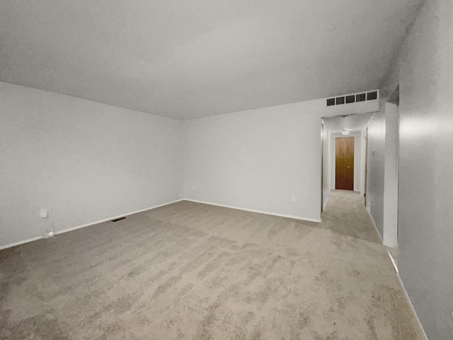 carpeted spare room featuring visible vents and baseboards