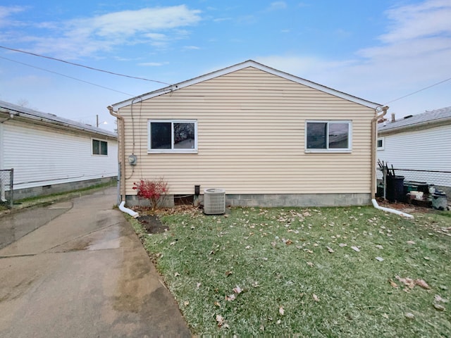 view of home's exterior featuring a yard, central AC, and fence