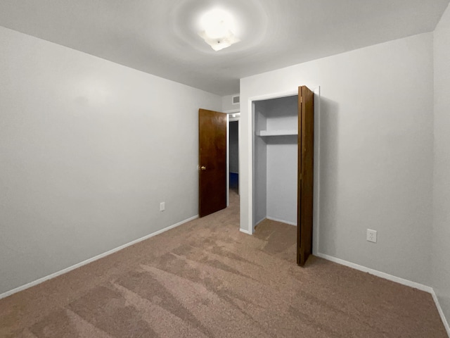 unfurnished bedroom with carpet floors, a closet, and baseboards