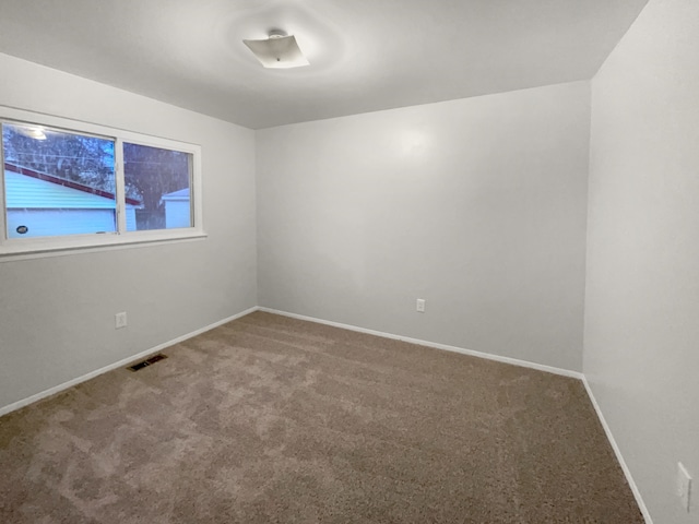 carpeted empty room with baseboards and visible vents