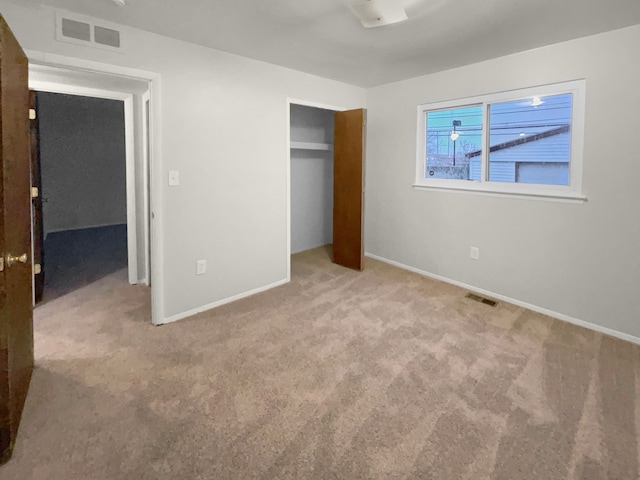unfurnished bedroom featuring carpet floors, a closet, visible vents, and baseboards