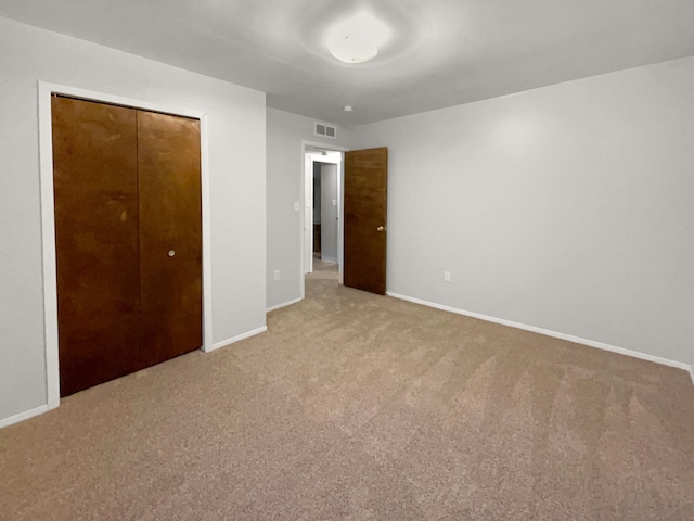 unfurnished bedroom with carpet, visible vents, and baseboards