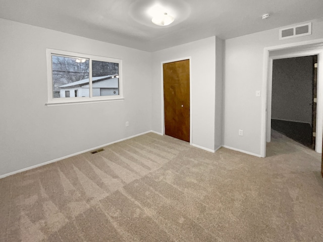 unfurnished bedroom with carpet floors, a closet, visible vents, and baseboards