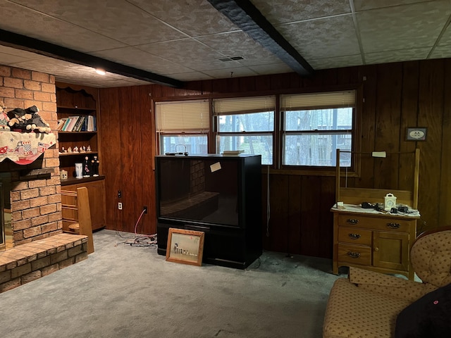 living room featuring light carpet, a brick fireplace, wooden walls, and visible vents