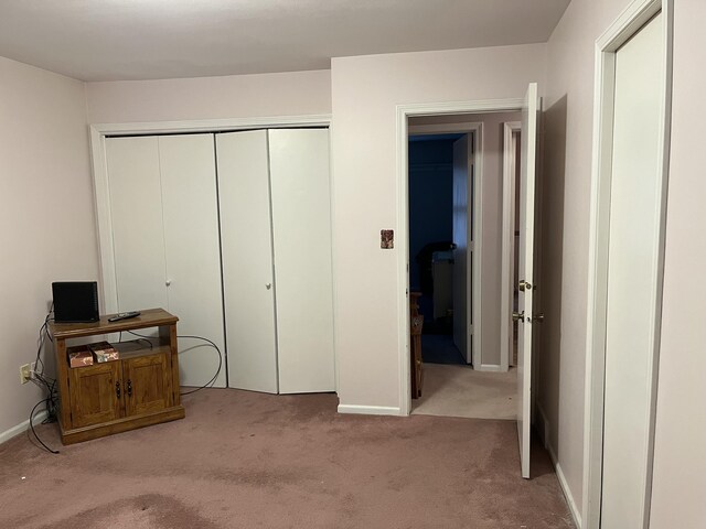 carpeted bedroom featuring baseboards and a closet