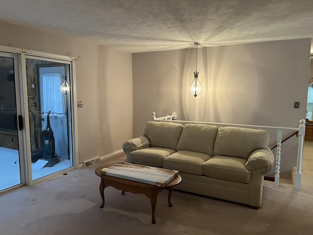 living area with light carpet, baseboards, visible vents, and a textured ceiling