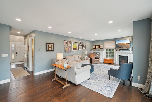 living room with hardwood / wood-style flooring, recessed lighting, baseboards, and a glass covered fireplace