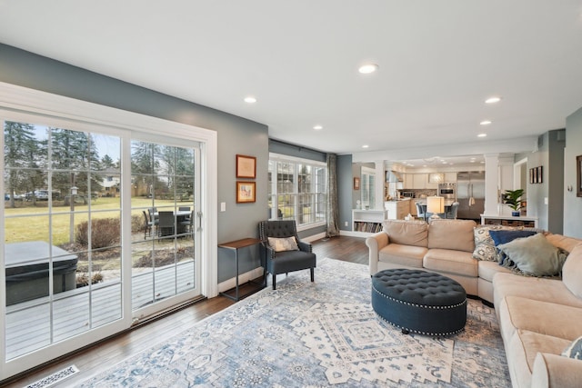 living room featuring decorative columns, recessed lighting, visible vents, wood finished floors, and baseboards