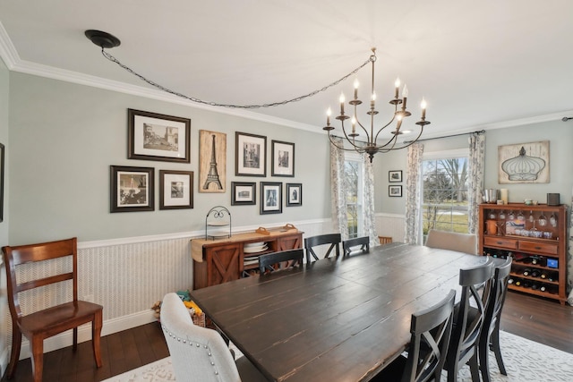 dining space featuring ornamental molding, dark wood-type flooring, and wainscoting