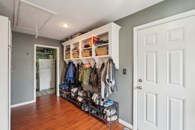 mudroom with attic access, baseboards, and wood finished floors