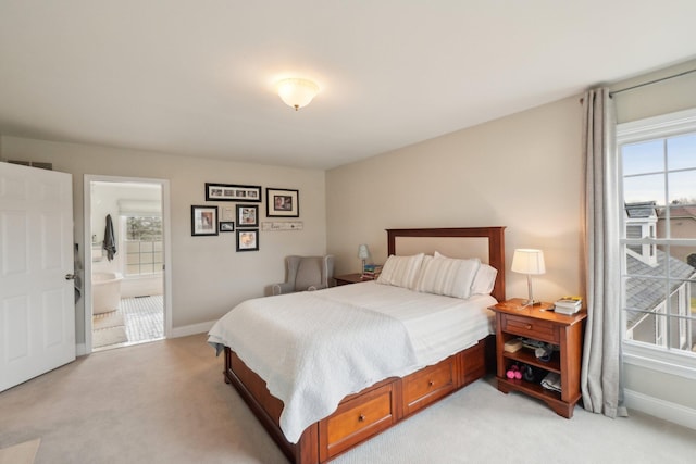 bedroom featuring light carpet, multiple windows, and baseboards