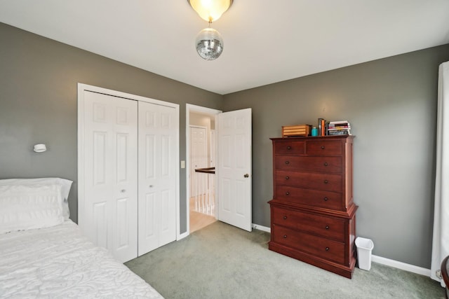 carpeted bedroom featuring a closet and baseboards