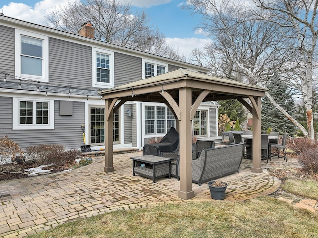 back of property with a patio, a chimney, a gazebo, and an outdoor hangout area