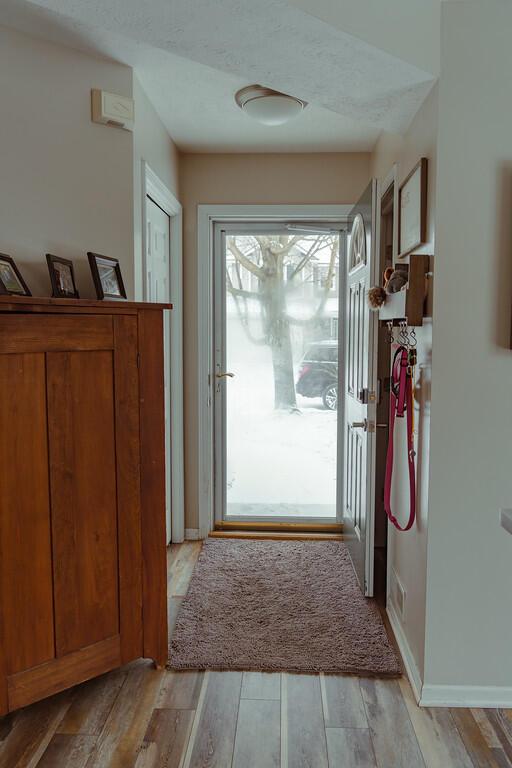 doorway featuring light wood-type flooring and baseboards