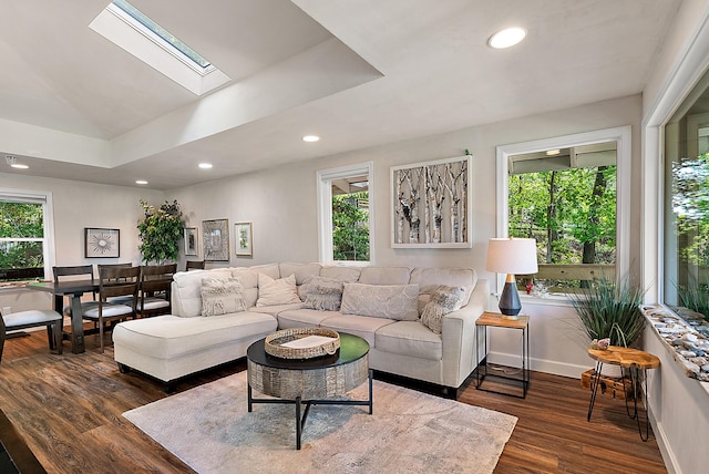 living room with dark wood-style floors, a skylight, baseboards, and recessed lighting