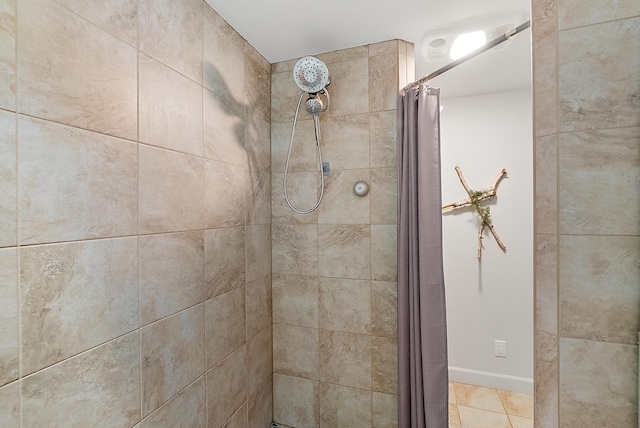 full bath with tiled shower and tile patterned flooring