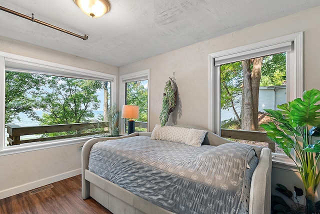 bedroom featuring visible vents, baseboards, and wood finished floors