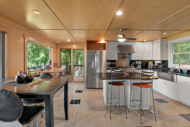 kitchen featuring appliances with stainless steel finishes, recessed lighting, dark countertops, and ventilation hood