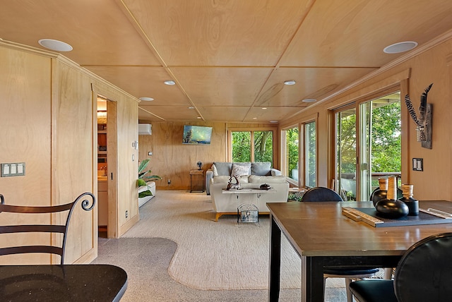 carpeted living room with wooden walls