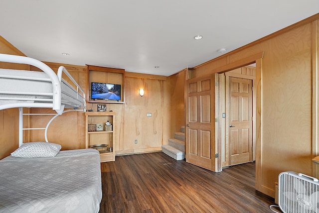 bedroom with wood walls and wood finished floors